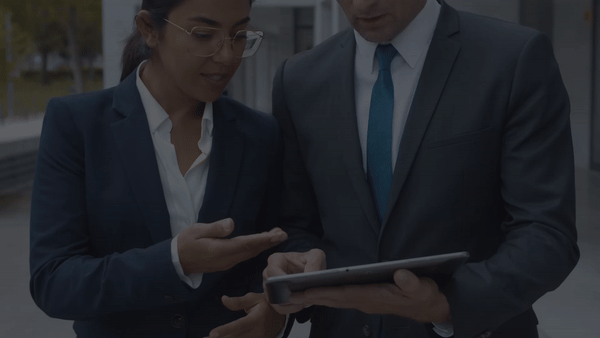Two pharmaceutical professionals reviewing information on a tablet